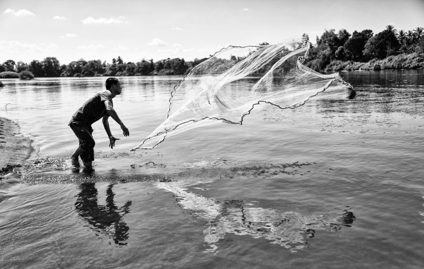 grayscale_photo_of_man_throwing_a_fishing_net_916405.jpg